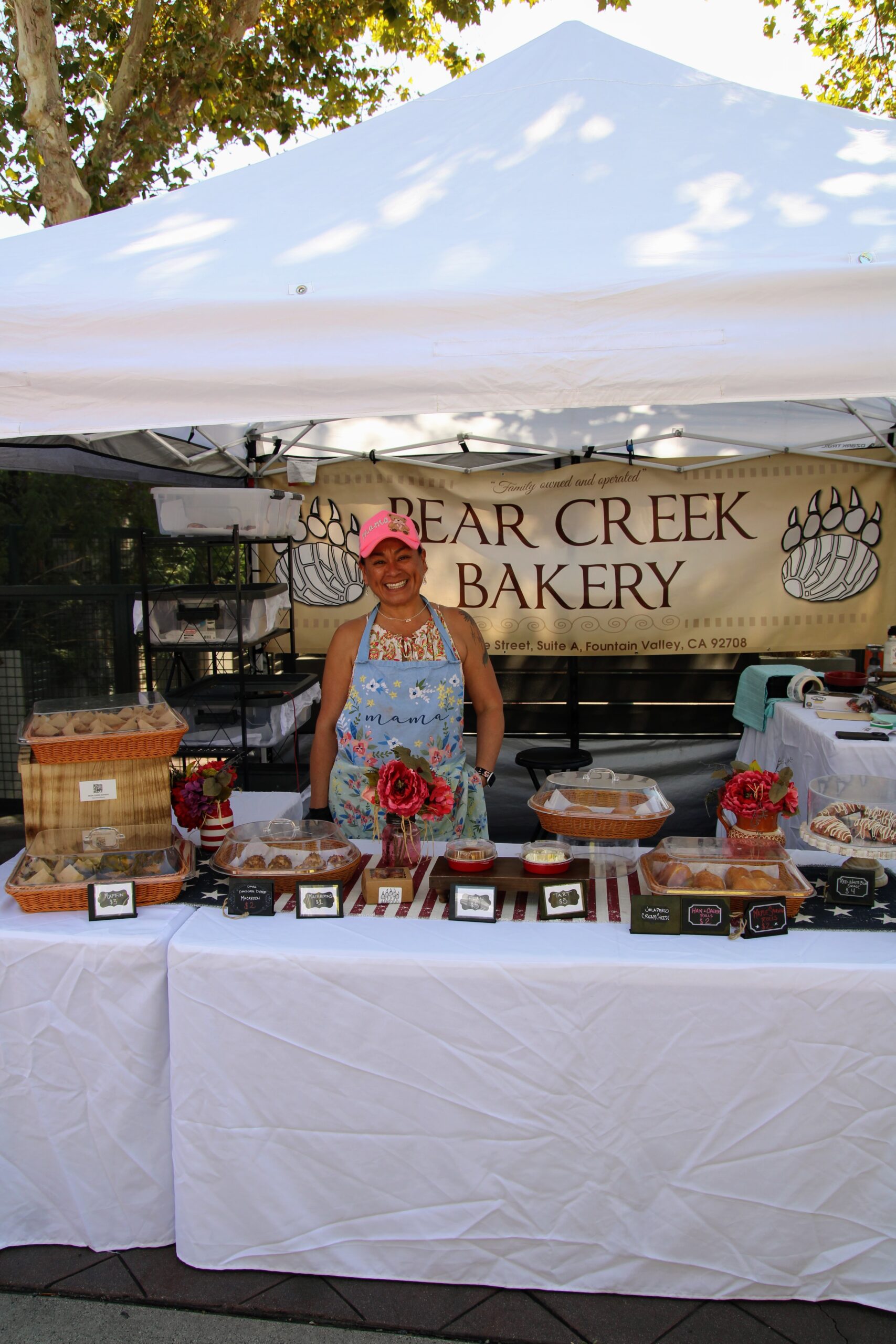 Smiling bakery vendor at a market stall