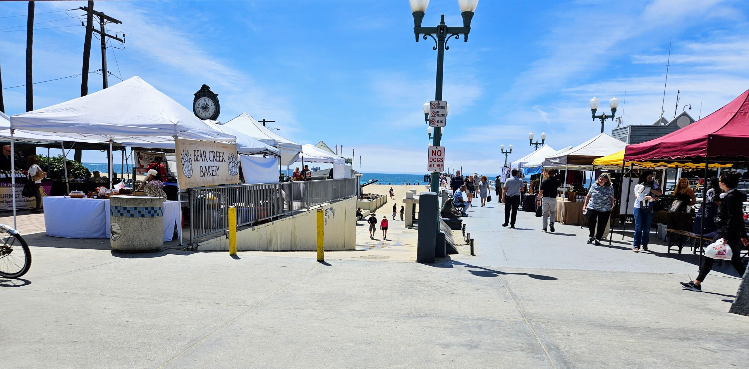 Beachside farmers market tents along the Seal Beach boardwalk