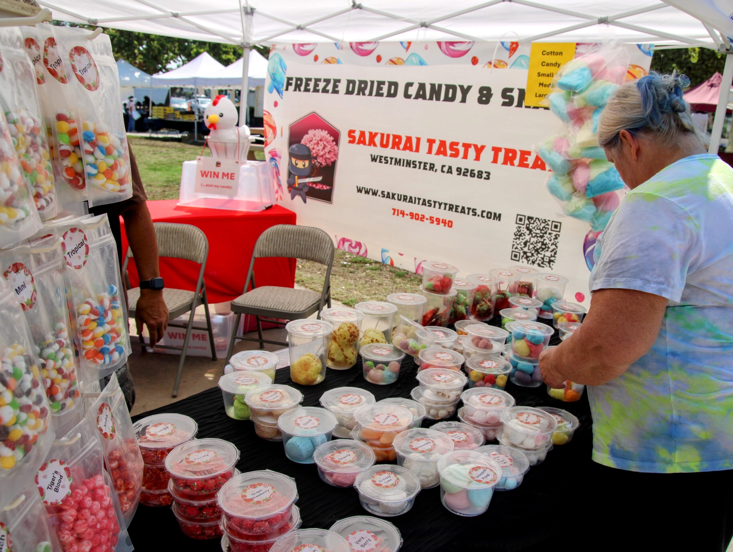 Candy vendor market stall with packaged sweets and cotton candy