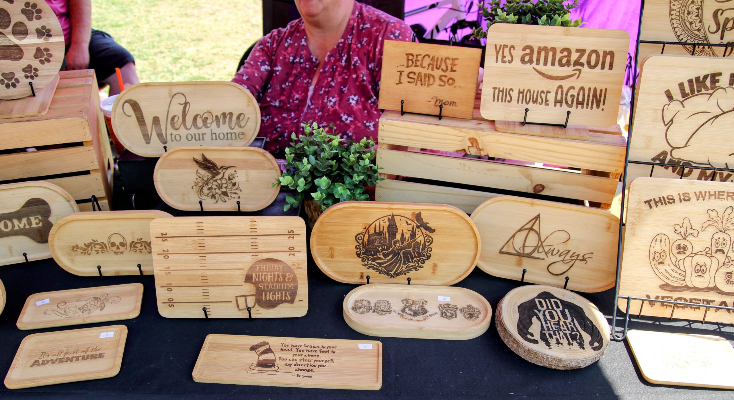 Engraved wooden signs and bamboo trays at a market booth