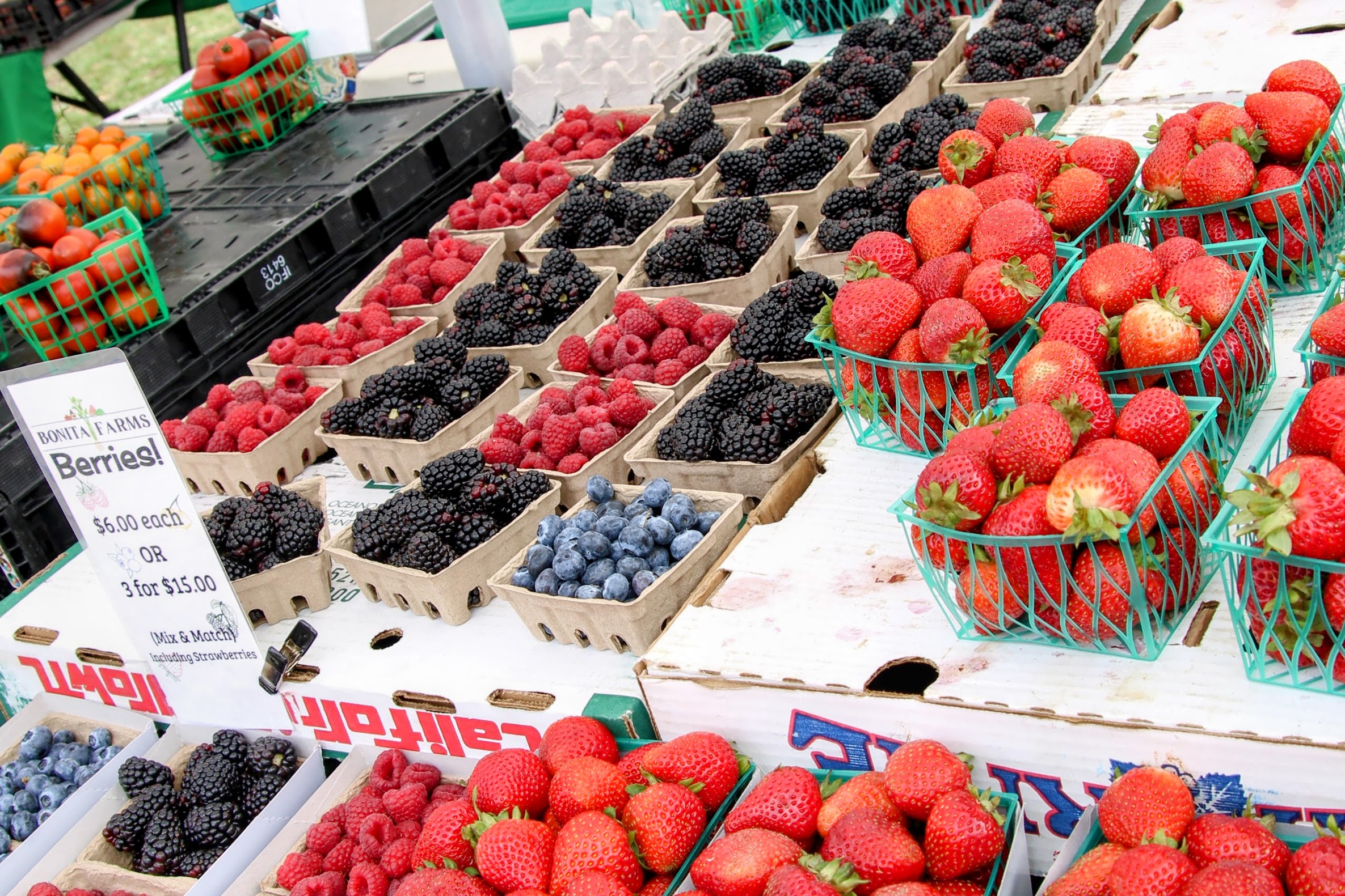 Fresh strawberries, raspberries, blackberries, and blueberries in baskets
