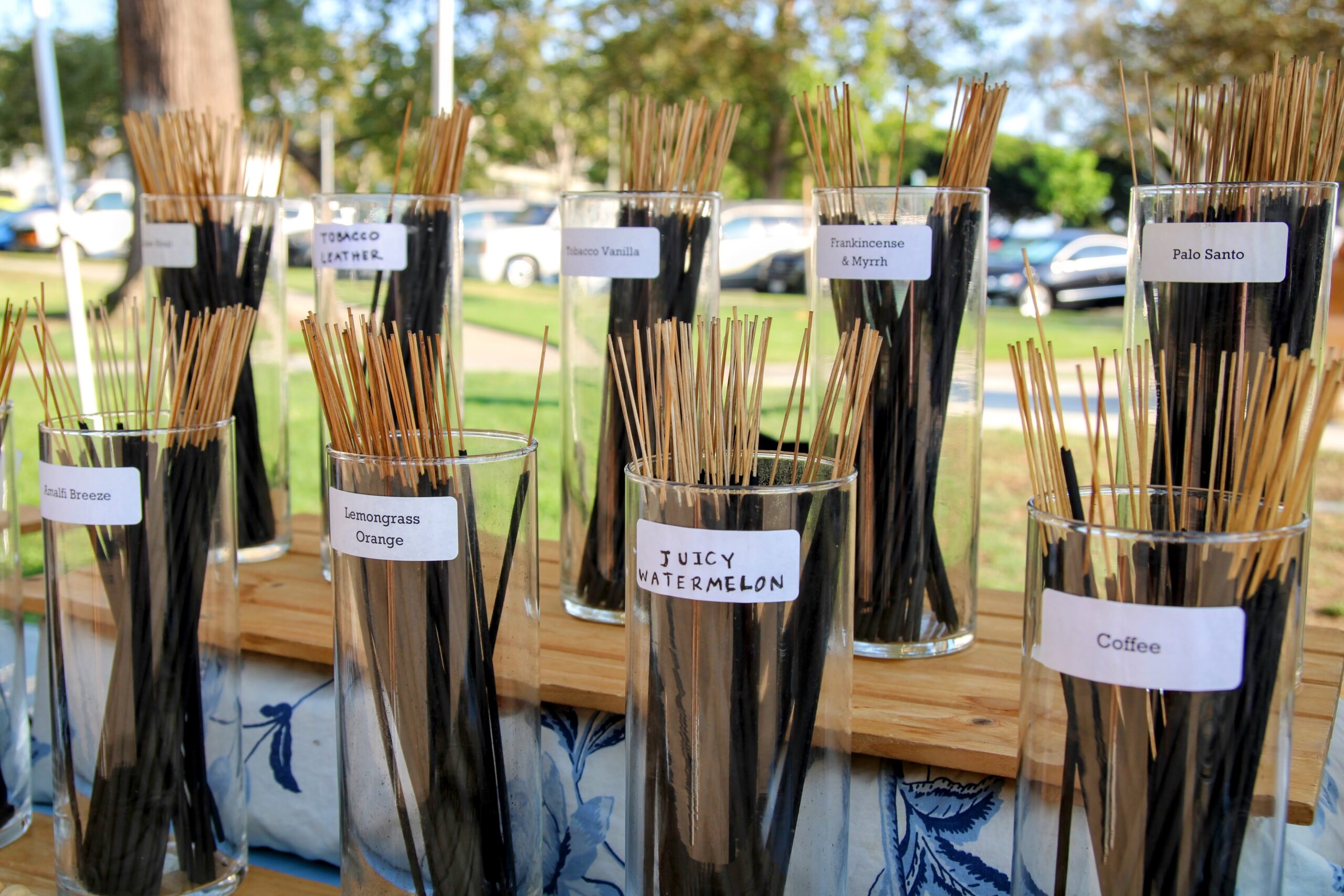Incense sticks displayed in labeled glass jars at a market booth