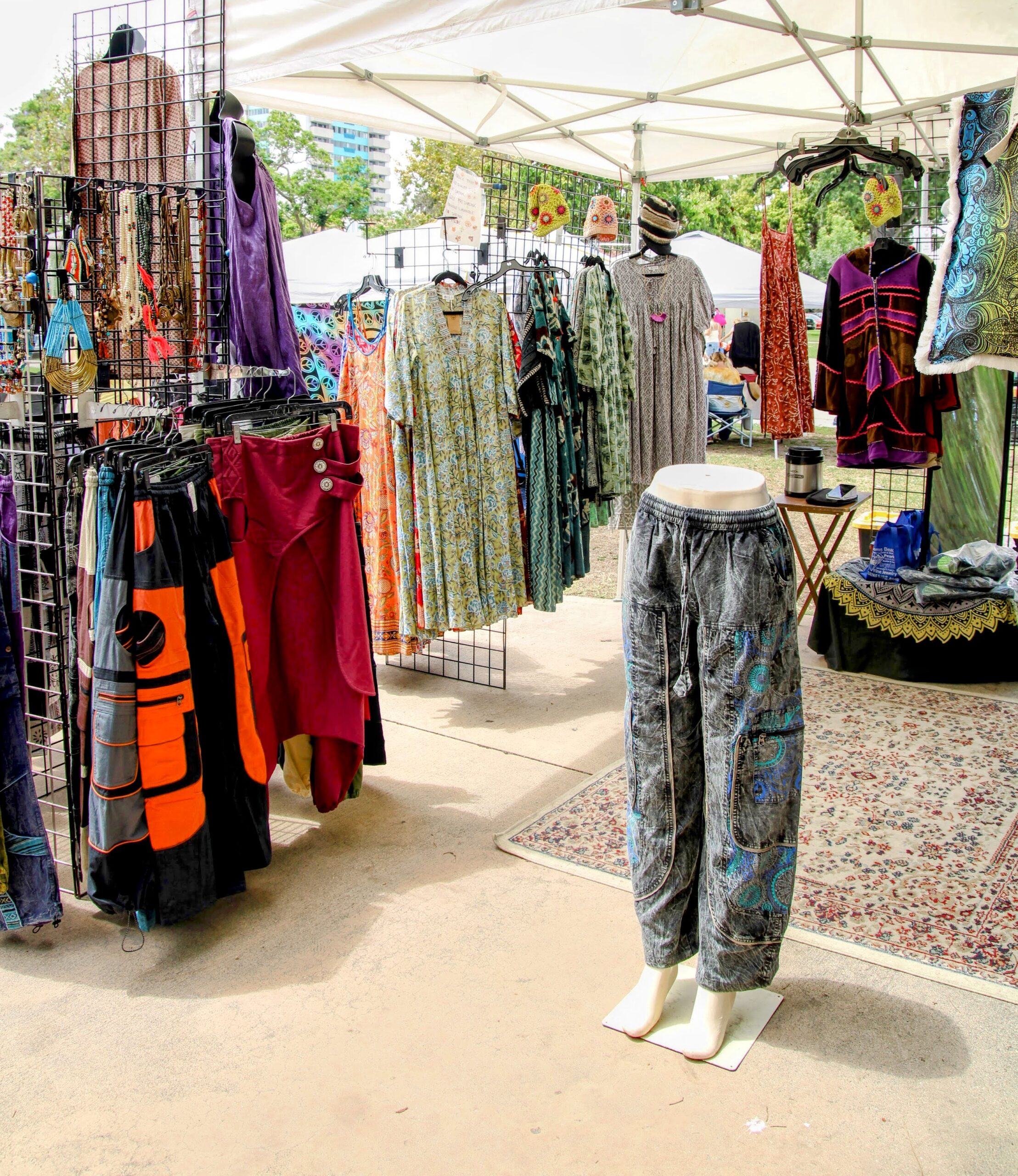 Outdoor clothing booth with dresses, pants, and mannequins